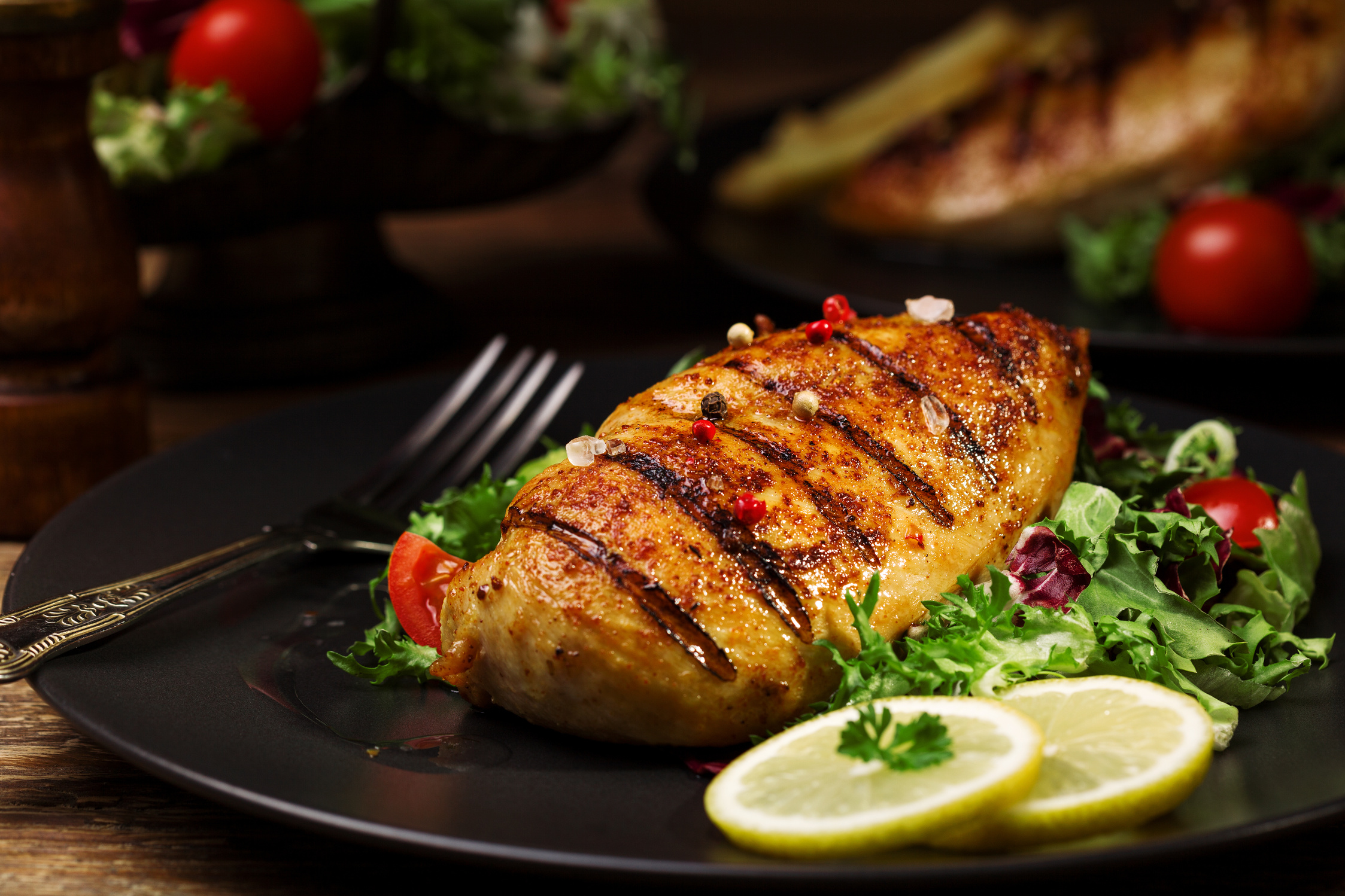 grilled chicken breast with green salad and french fries.